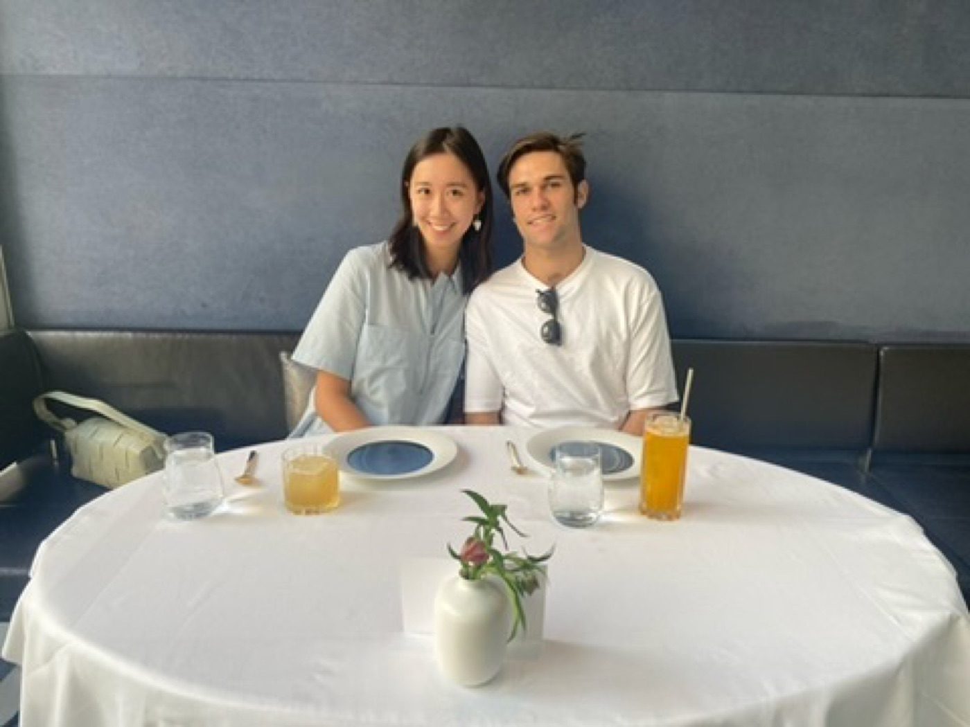 Noel and his partner smiling at a bright minimalist restaurant table
