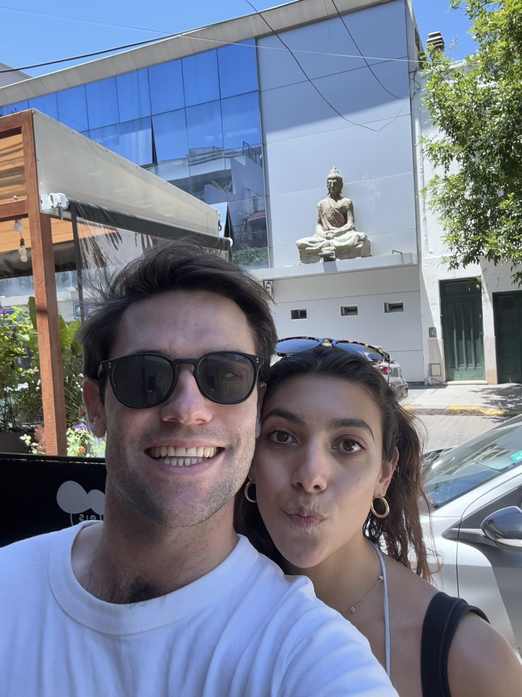 Playful sunglasses street selfie with his partner in Buenos Aires