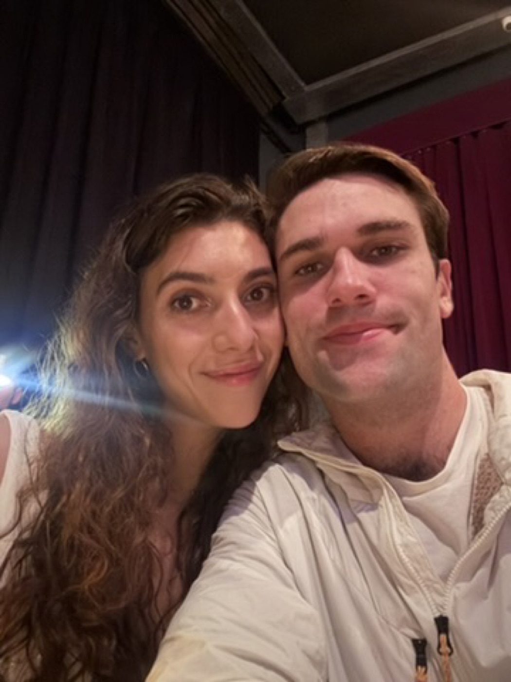 Cozy cheek-to-cheek couple selfie in a dim warm-lit room