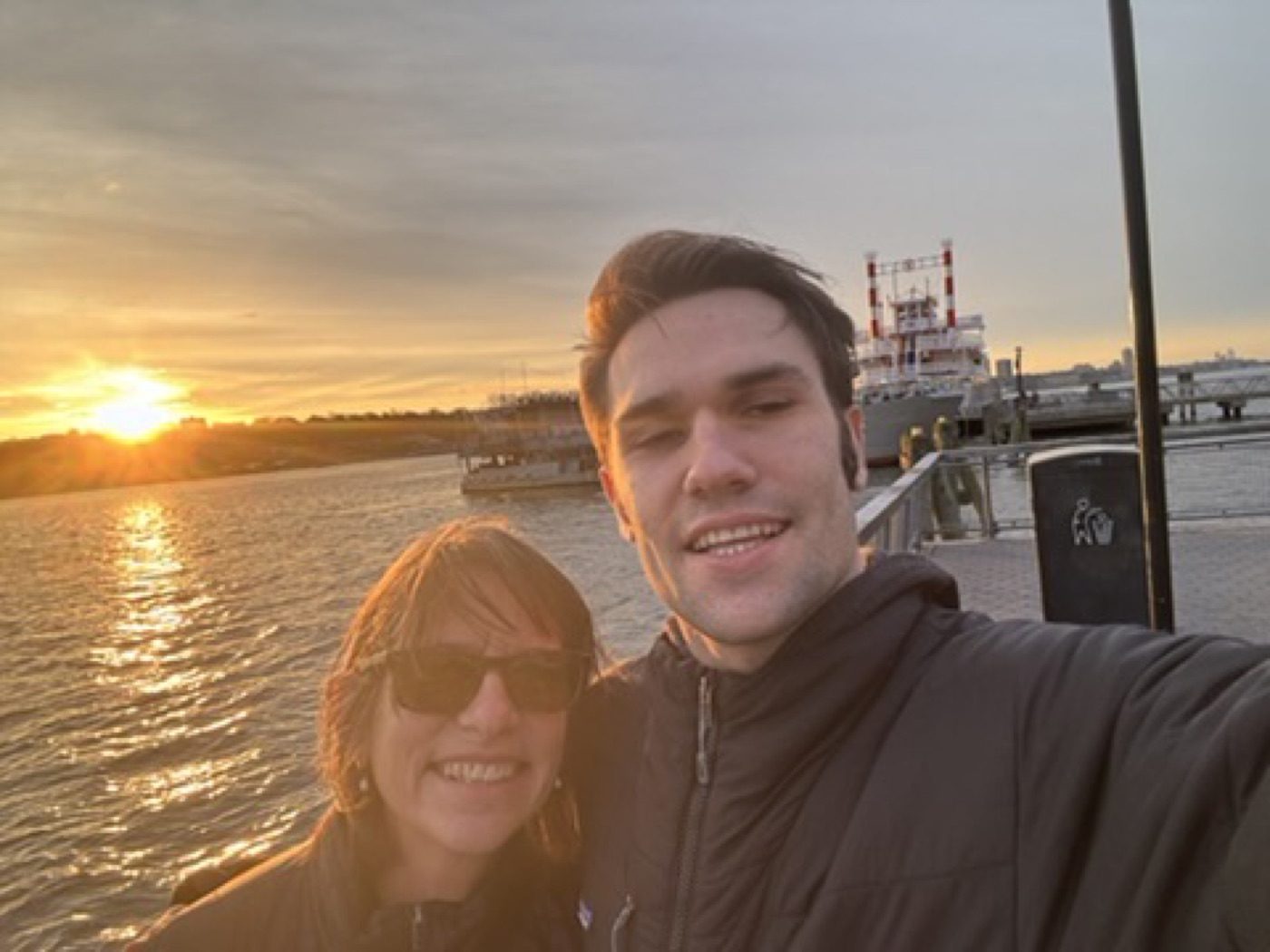 Golden Hudson-sunset selfie with his mom, sun flaring behind