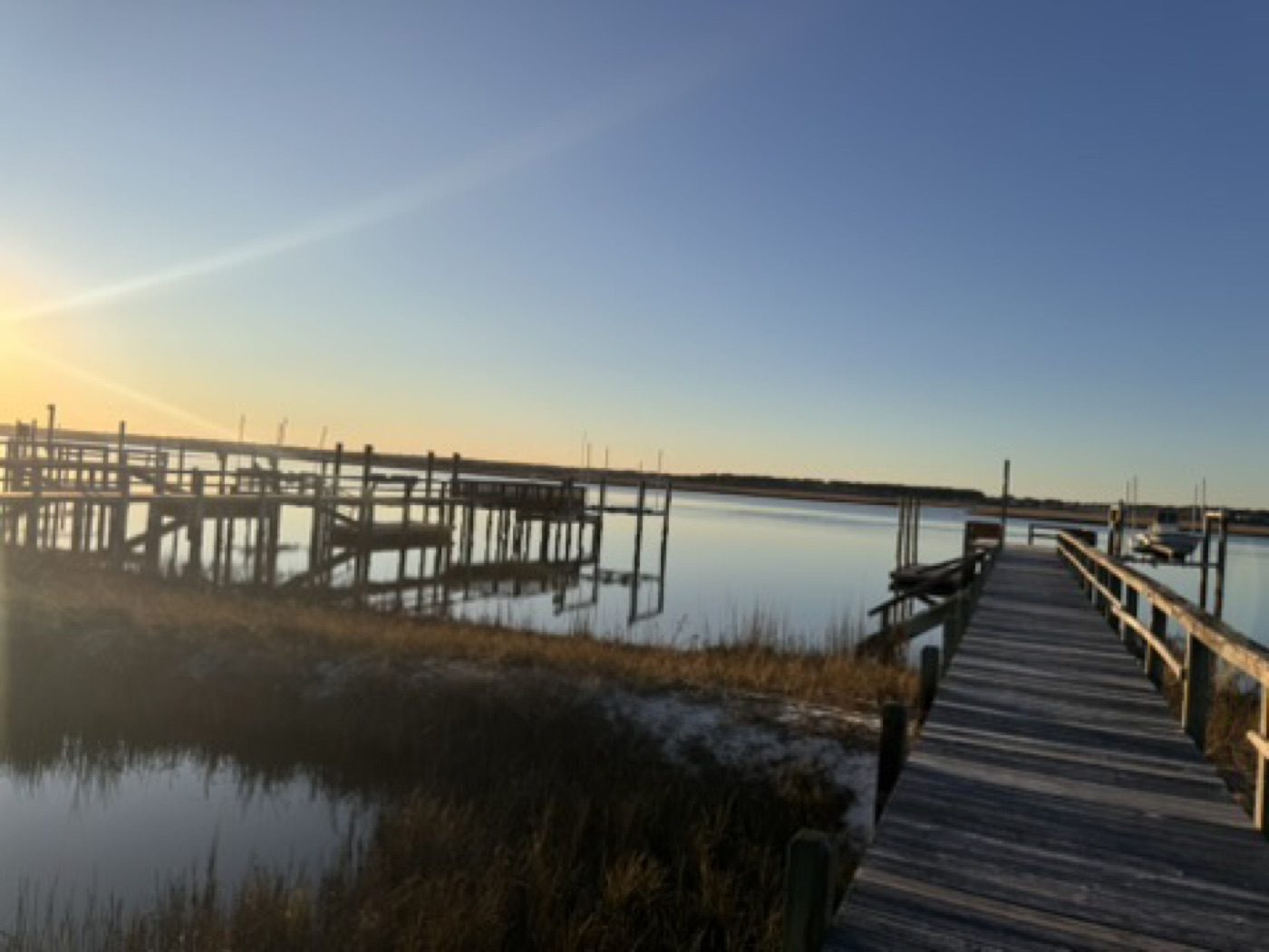 Golden-hour marsh with weathered docks and still water