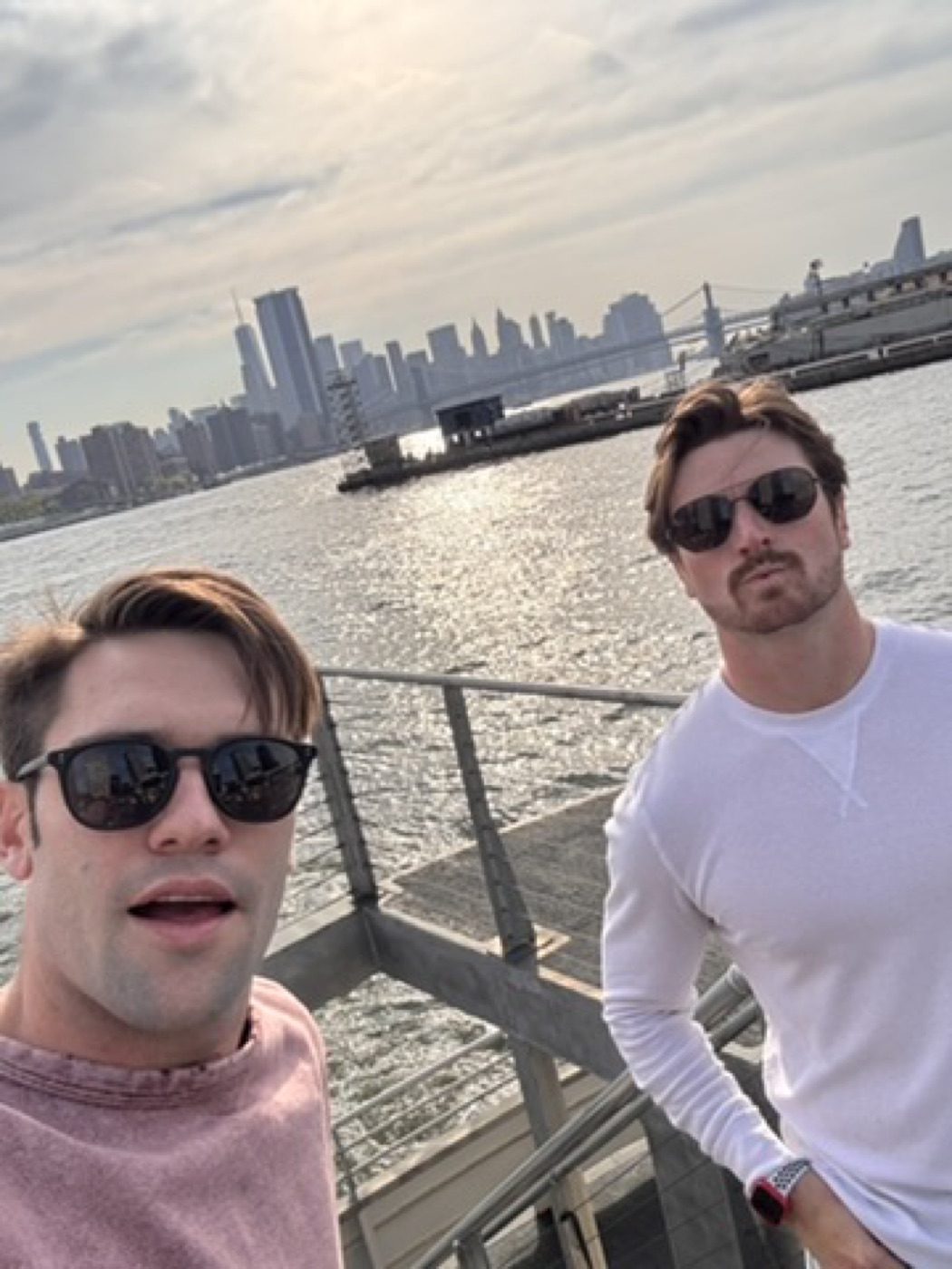 Two guys' ferry selfie against the sunny NYC skyline