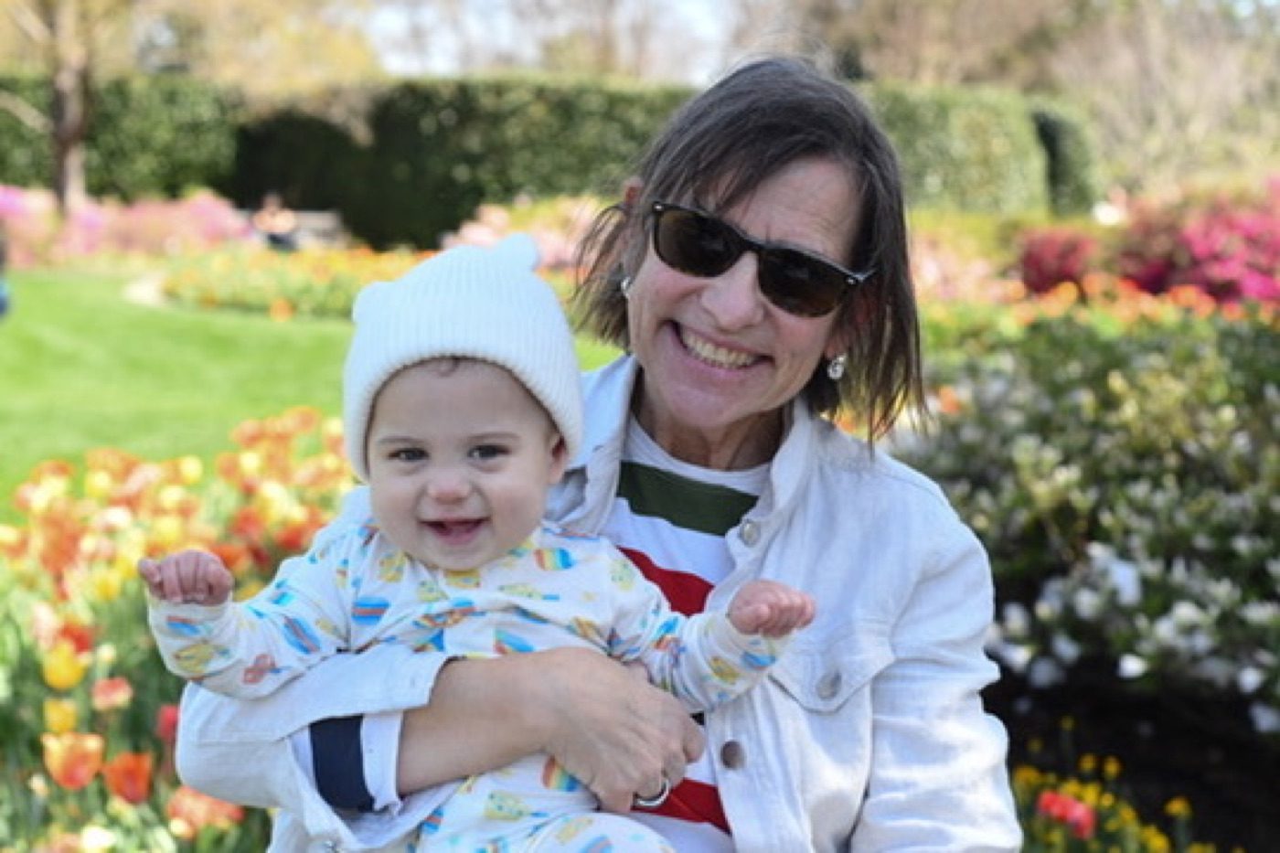 Grandmother and baby in a colorful tulip garden