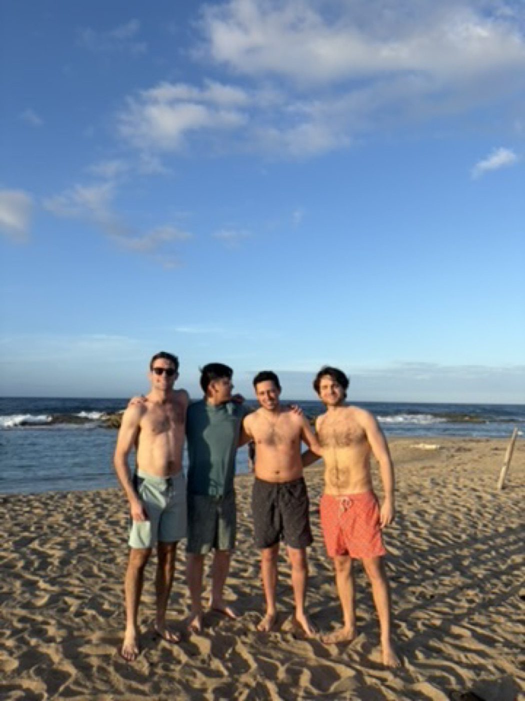 Four friends on the beach, relaxed blue-sky energy
