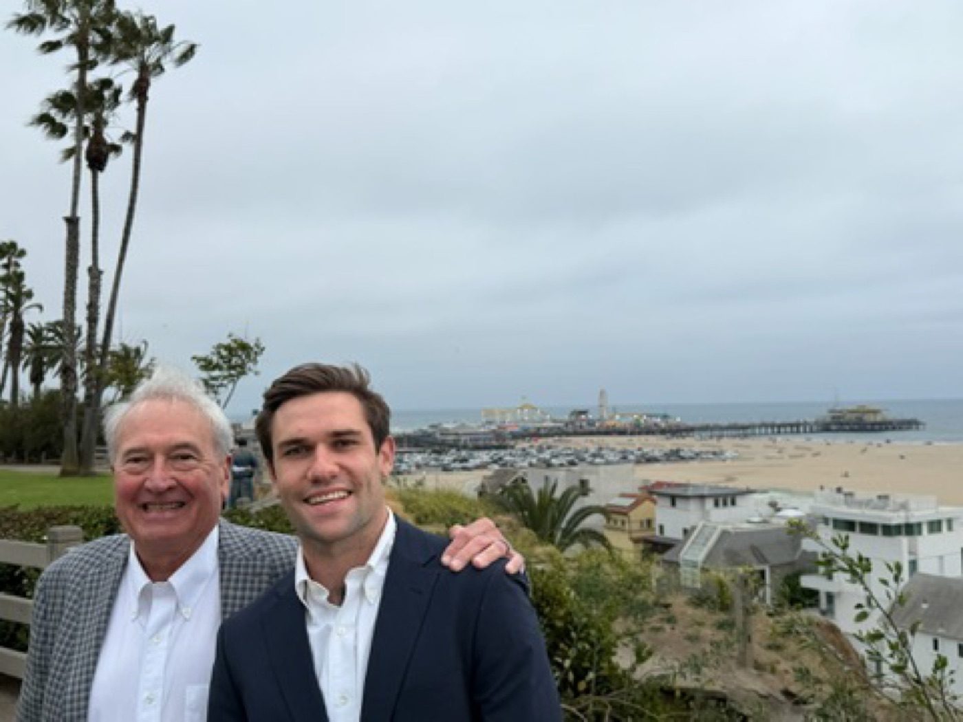 Noel arm-around an older mentor over the Santa Monica coast