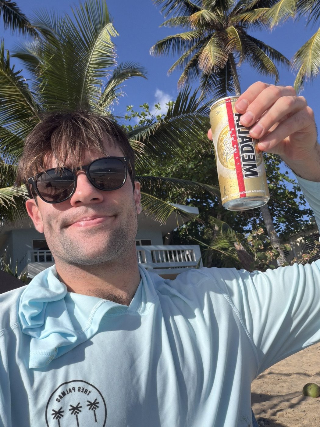 Goofy palm-tree beer selfie in sunglasses