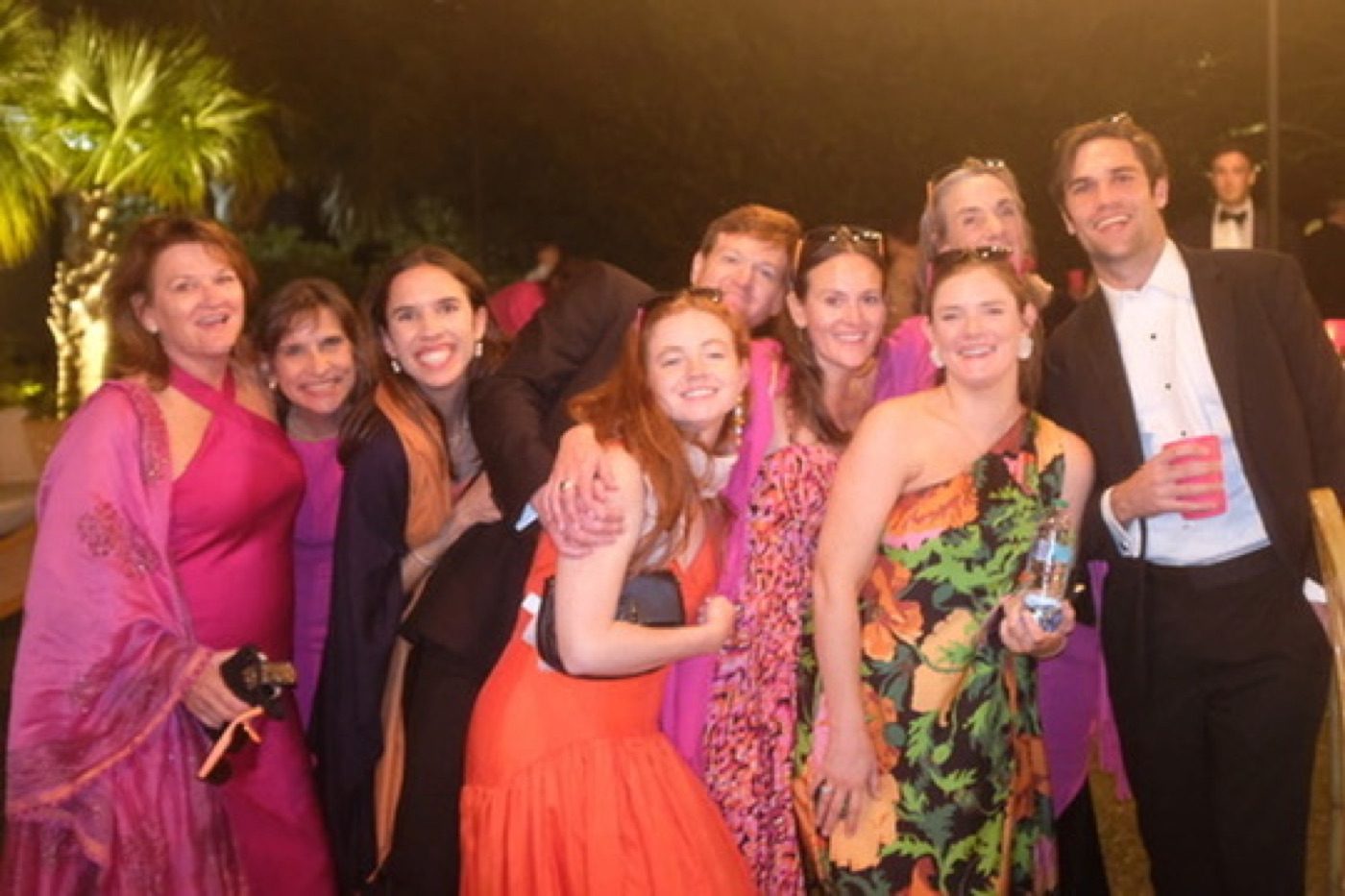 Family and friends laughing in a warm nighttime crowd