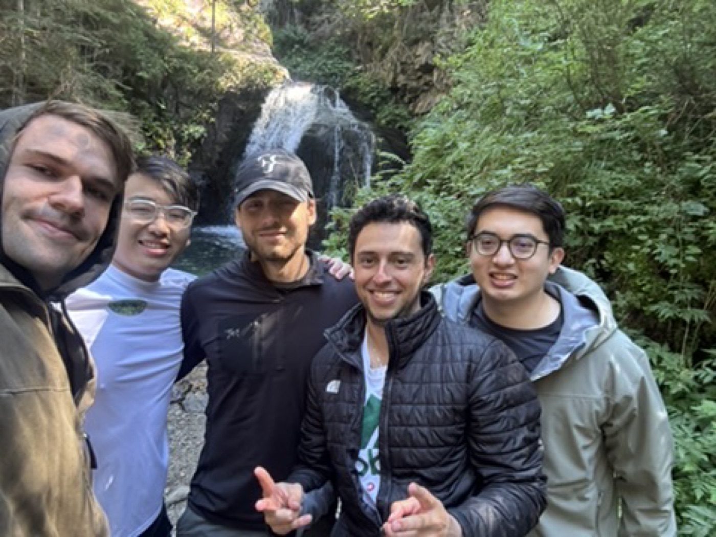 Five buddies squeezed together for a waterfall selfie