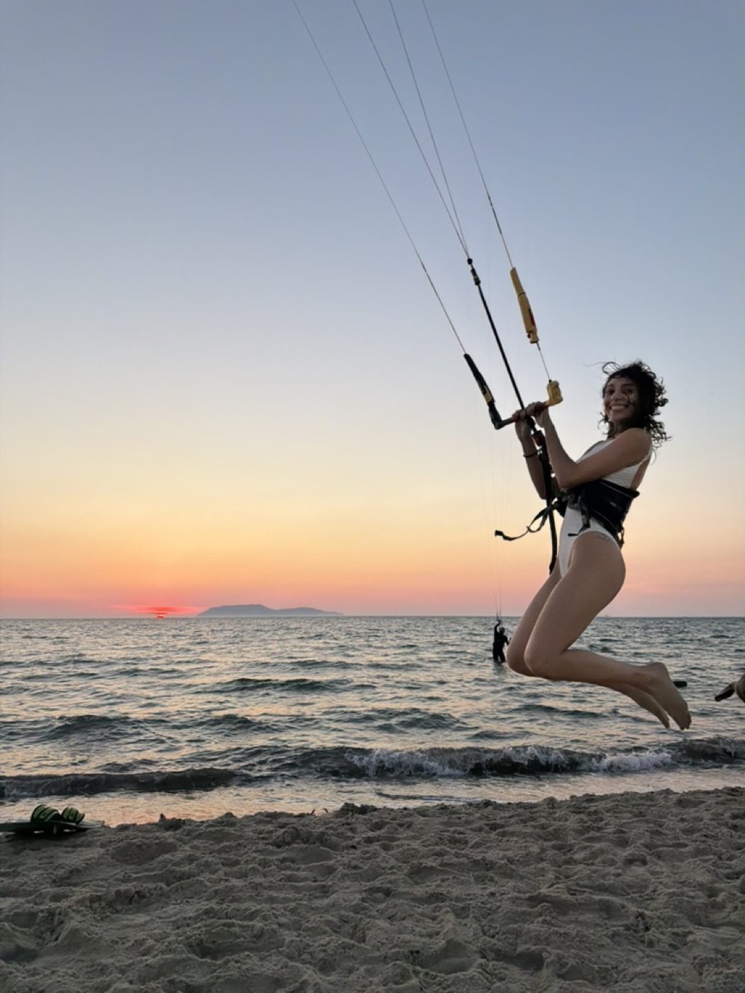 Kitesurfer mid-jump at sunset, joyful and dynamic