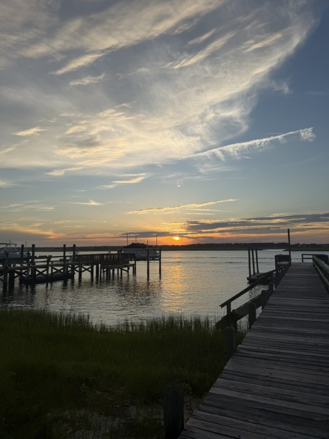 Dock boardwalk leading into a calm sunset