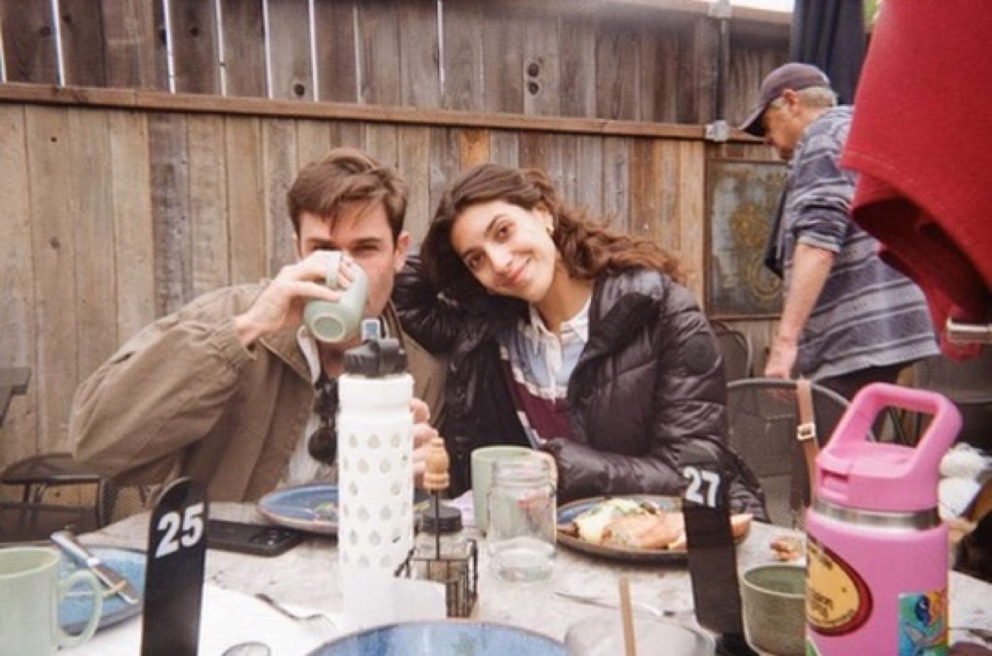 Noel and partner cozy together at an outdoor meal