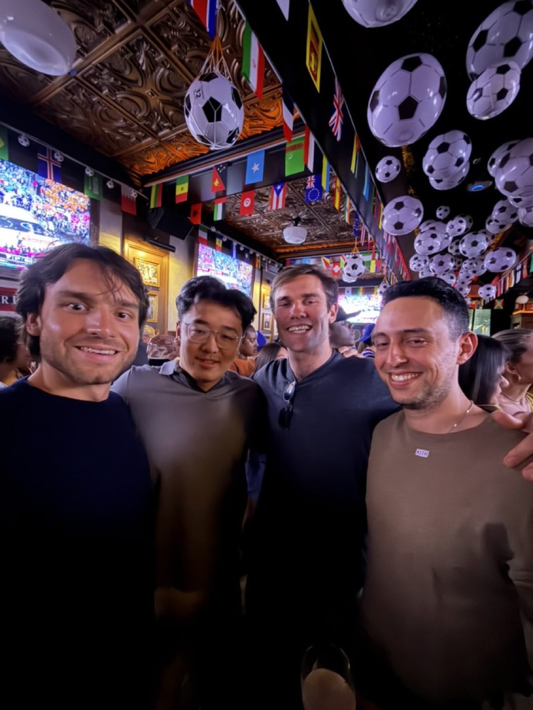 Noel and three buddies grinning at the soccer bar