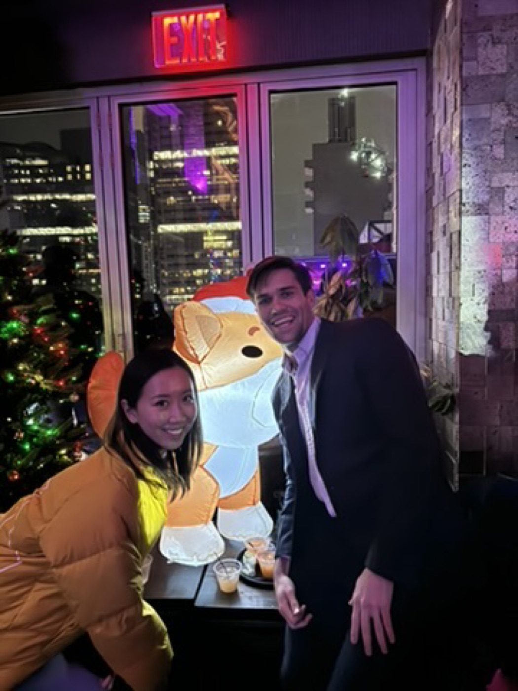 Noel and partner at a festive rooftop holiday bar downtown