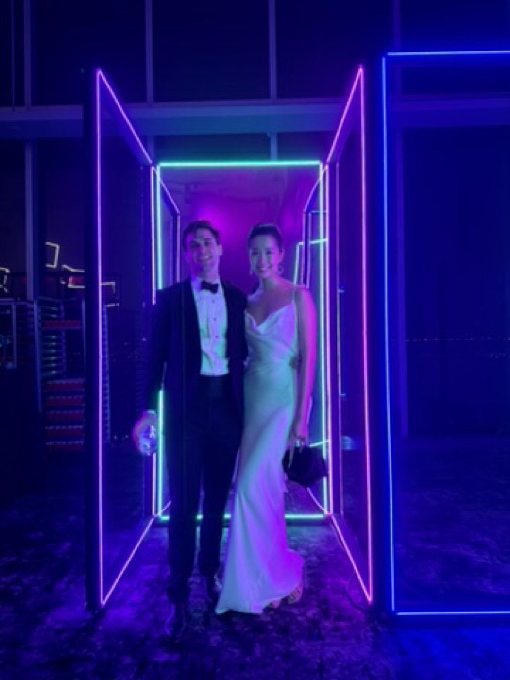 Dressed up together, framed in glowing neon doorway lights