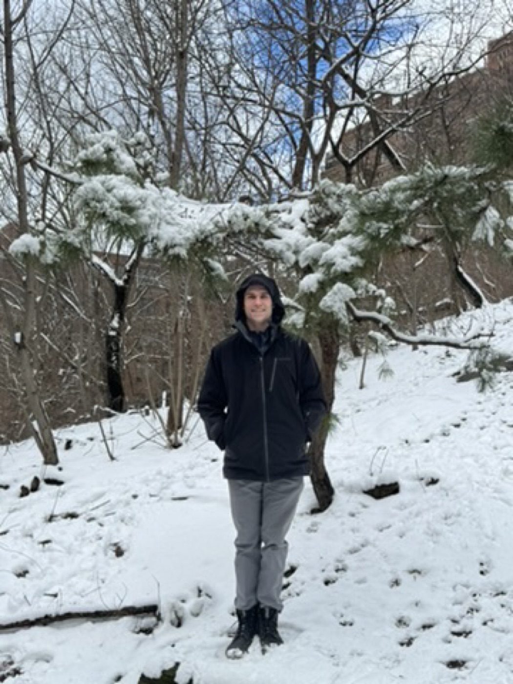 Bundled up beneath a snow-dusted pine in the woods