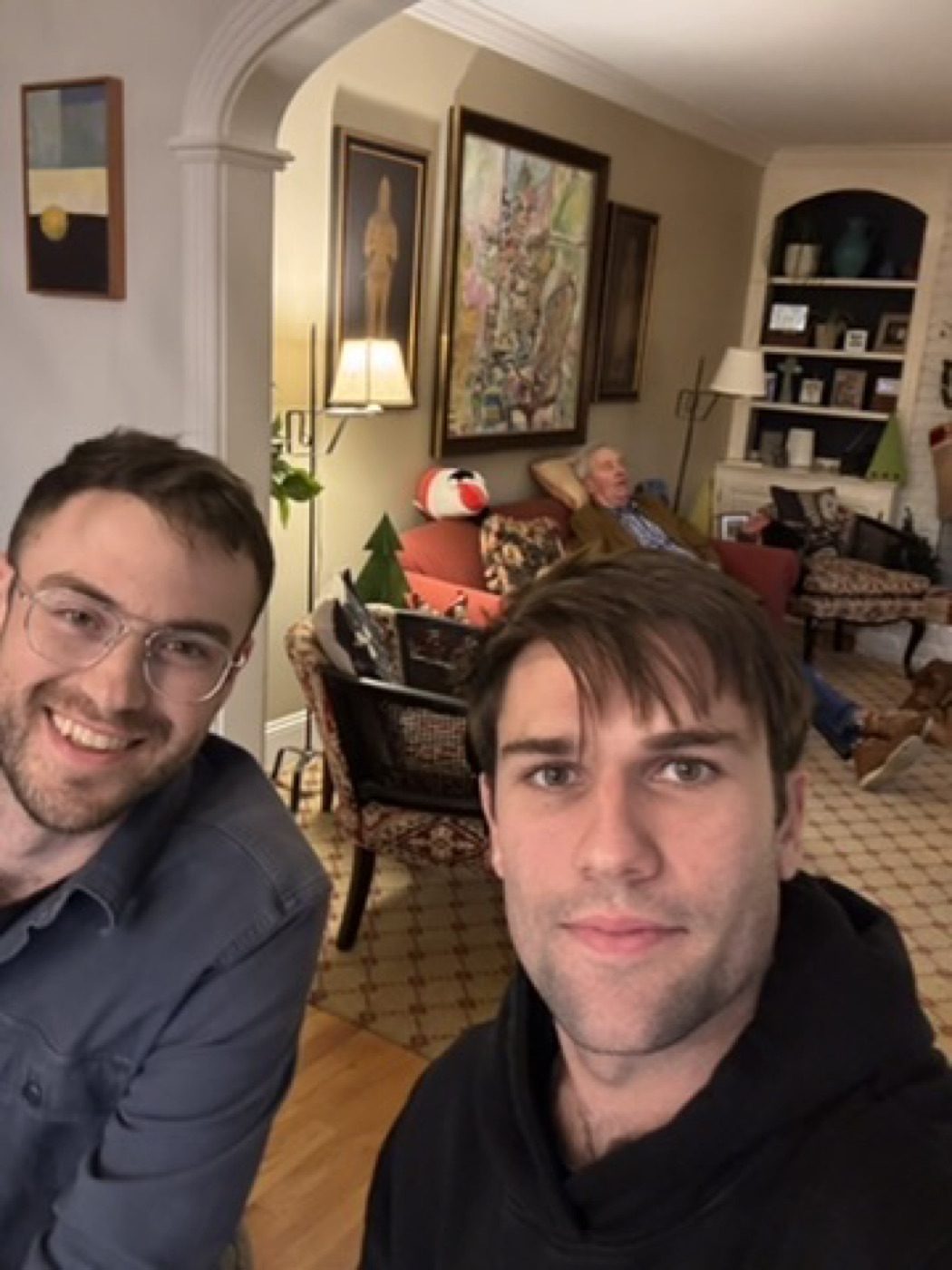 Two friends smiling in a warm family living room