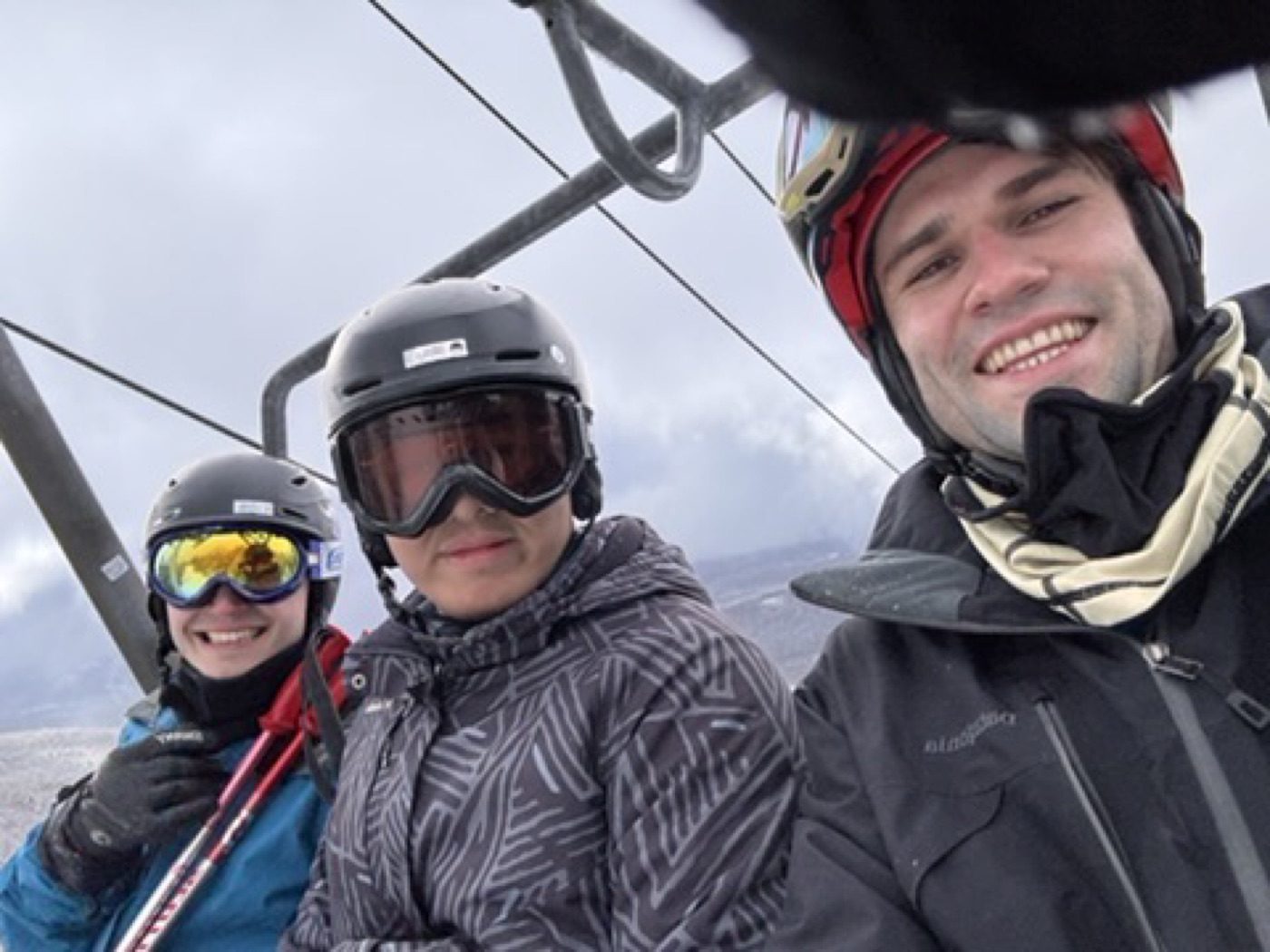 Chairlift trio selfie, all bundled and smiling on the mountain