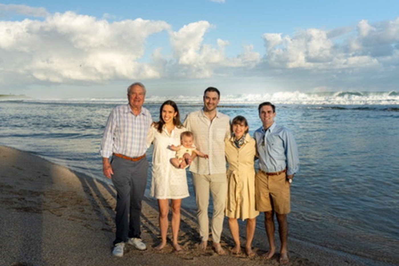 Full family portrait with a dramatic surf backdrop