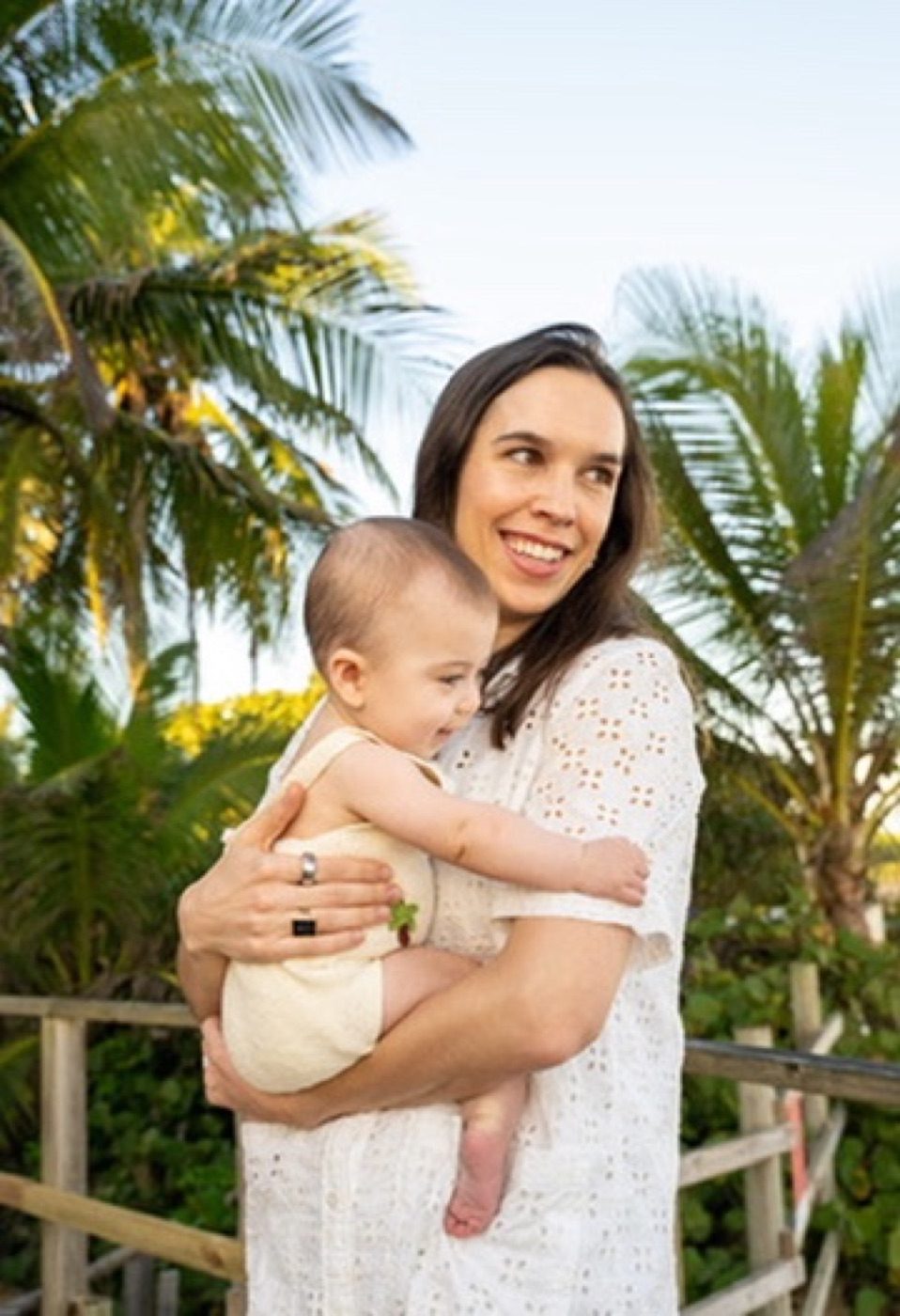 Woman in white eyelet with a laughing baby