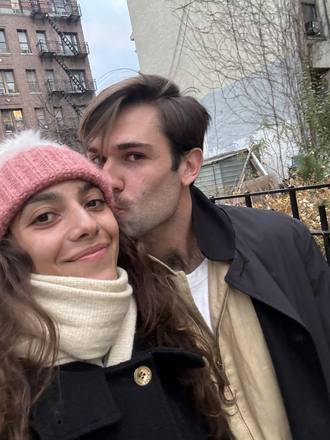 Winter street selfie, Noel kissing his partner's cheek